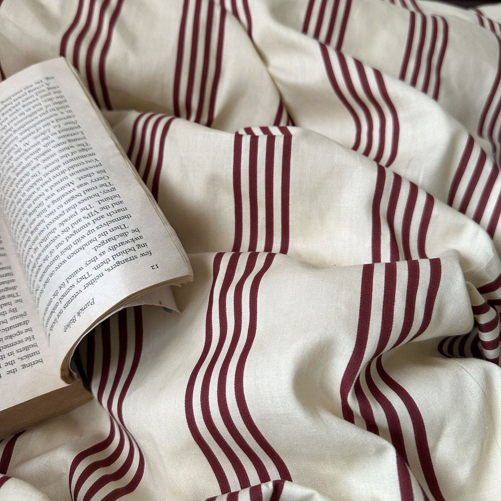 Open book on a surface with red and white striped fabric